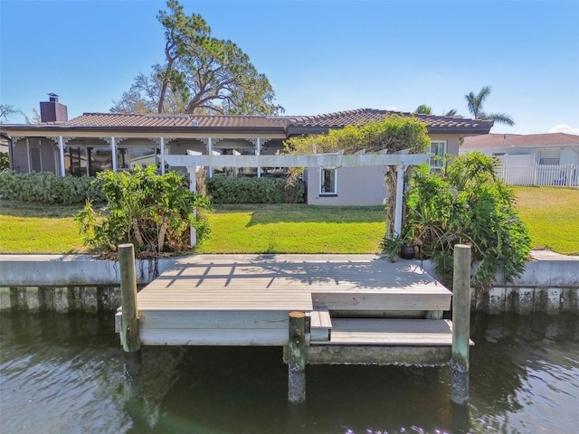 view of dock with a water view and a lawn