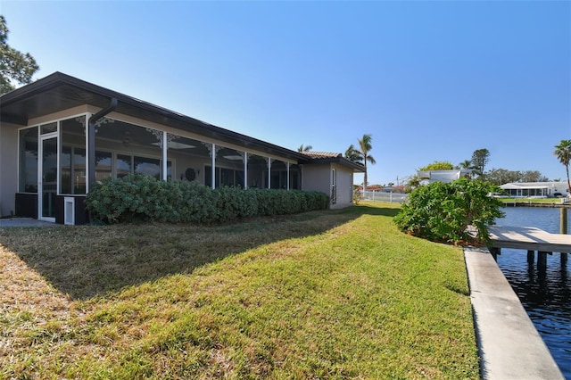 view of yard featuring a water view and a sunroom