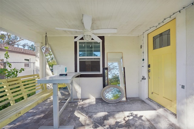 entrance to property featuring ceiling fan and a porch