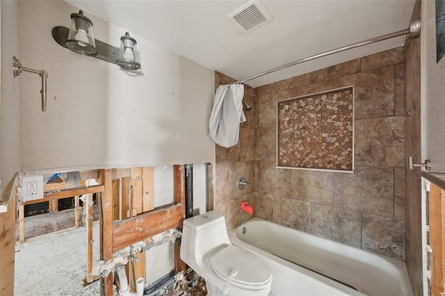 bathroom with tiled shower / bath combo and toilet