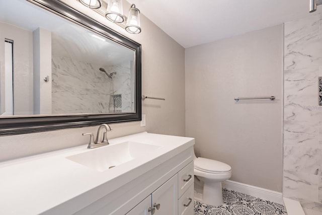 bathroom featuring tile patterned floors, vanity, tiled shower, and toilet