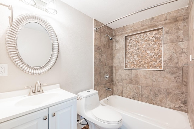 full bathroom featuring vanity, tiled shower / bath combo, and toilet