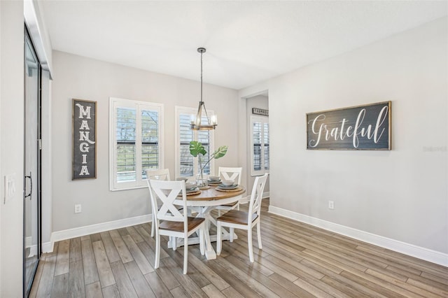 dining area with a notable chandelier and hardwood / wood-style flooring