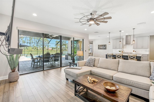 living room with light wood-type flooring and ceiling fan