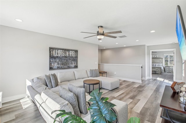 living room with ceiling fan and light hardwood / wood-style flooring