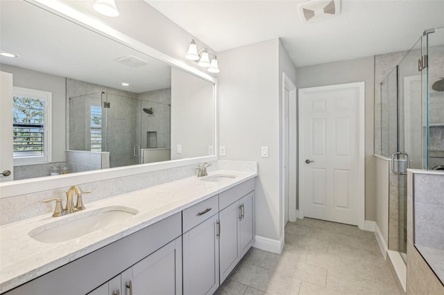 bathroom with an enclosed shower, vanity, and tile patterned floors