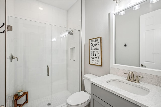 bathroom featuring walk in shower, vanity, and toilet