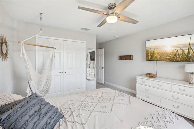 bedroom with ceiling fan, a closet, and light carpet