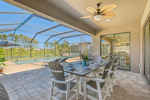 view of patio with a lanai, ceiling fan, and a fenced in pool