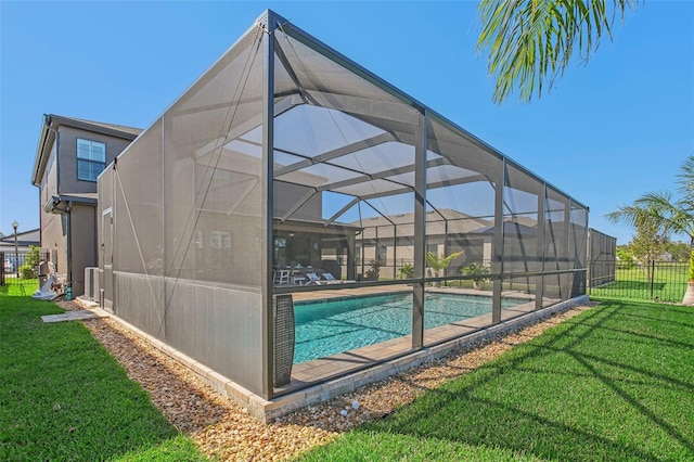 view of swimming pool with glass enclosure and a lawn