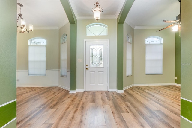 entryway with ceiling fan with notable chandelier, light hardwood / wood-style flooring, and ornamental molding