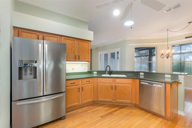 kitchen with crown molding, sink, light hardwood / wood-style floors, and stainless steel appliances