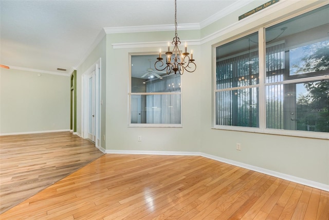 unfurnished dining area with hardwood / wood-style floors, a notable chandelier, and crown molding