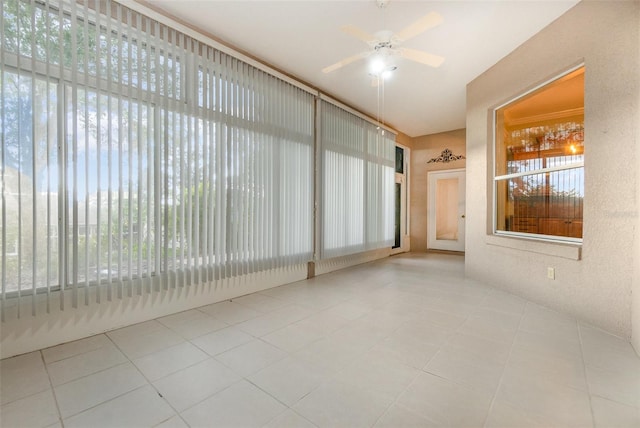 unfurnished sunroom featuring ceiling fan