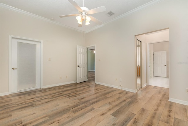 spare room featuring ornamental molding, light wood-type flooring, and ceiling fan