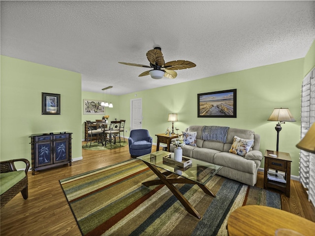 living room featuring ceiling fan, dark hardwood / wood-style floors, and a textured ceiling