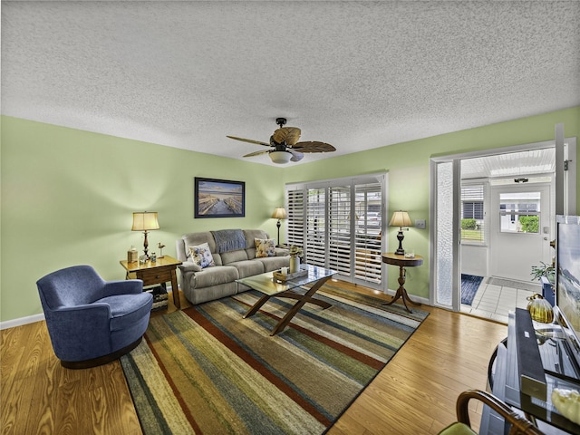 living room with hardwood / wood-style floors, a wealth of natural light, and ceiling fan