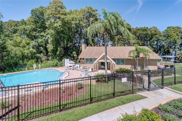 view of pool with a patio area and a yard