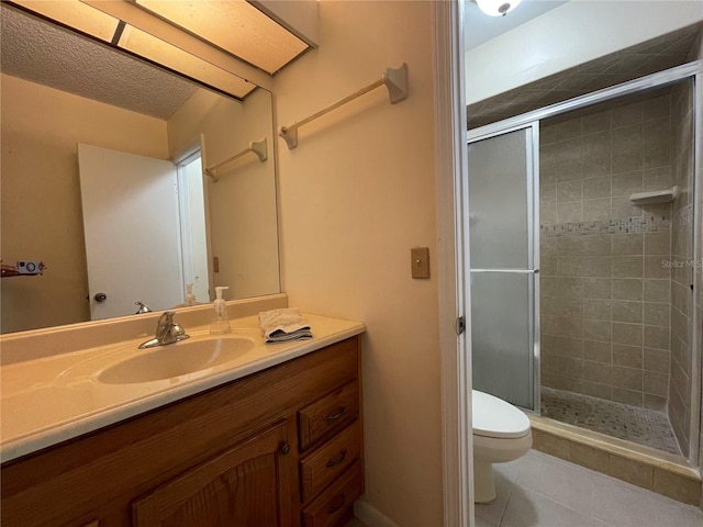 bathroom featuring a textured ceiling, vanity, a shower with shower door, tile patterned floors, and toilet