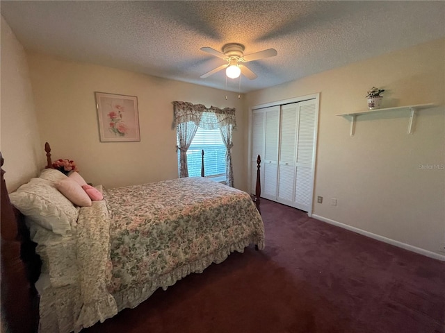 bedroom with a textured ceiling, dark colored carpet, ceiling fan, and a closet