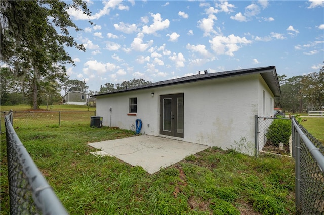 back of property featuring french doors, a yard, a patio area, and cooling unit