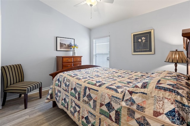 bedroom with ceiling fan, light wood-type flooring, and vaulted ceiling