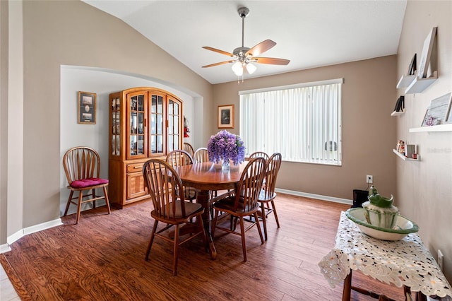 dining space featuring ceiling fan, lofted ceiling, and wood-type flooring