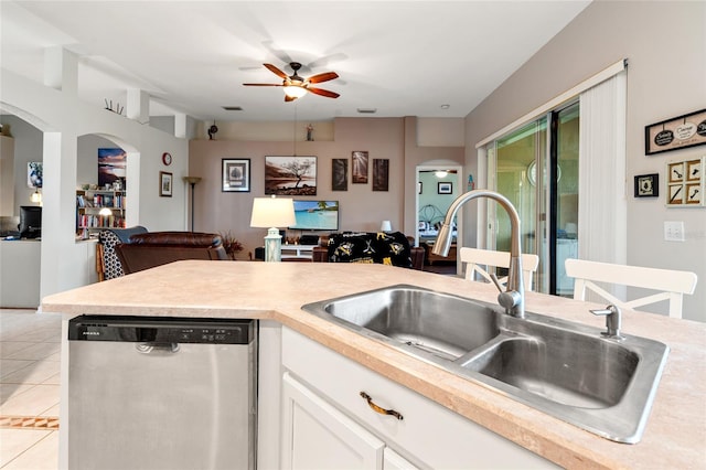 kitchen with white cabinets, sink, light tile patterned flooring, ceiling fan, and stainless steel dishwasher