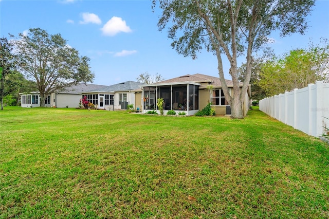 back of property with a sunroom and a yard