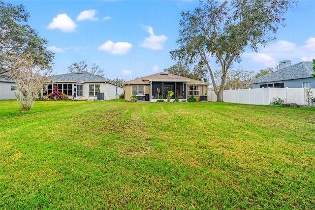 rear view of property featuring a sunroom and a yard