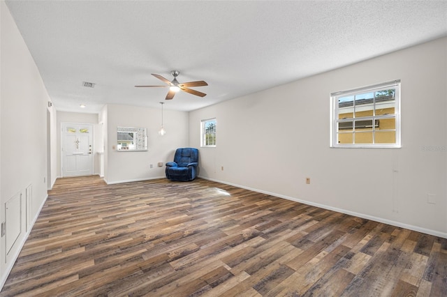 spare room featuring ceiling fan, dark wood-type flooring, and a textured ceiling