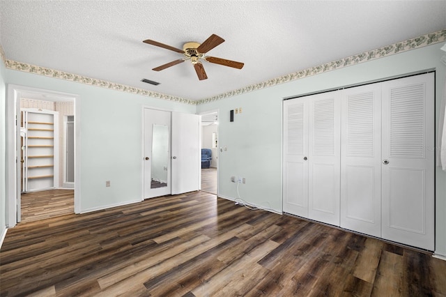 unfurnished bedroom with ceiling fan, dark hardwood / wood-style floors, and a textured ceiling