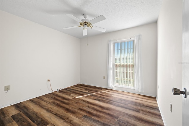 empty room with ceiling fan, dark wood-type flooring, and a textured ceiling