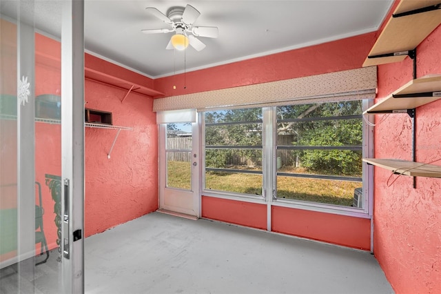 unfurnished sunroom with ceiling fan