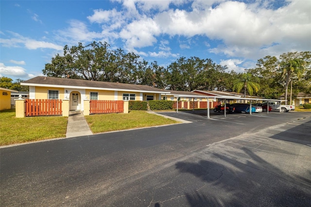 ranch-style house with a carport and a front lawn