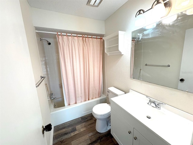 full bathroom featuring shower / bathtub combination with curtain, hardwood / wood-style floors, a textured ceiling, toilet, and vanity