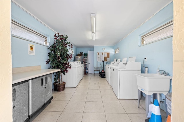 washroom with washer and clothes dryer, a healthy amount of sunlight, and light tile patterned flooring