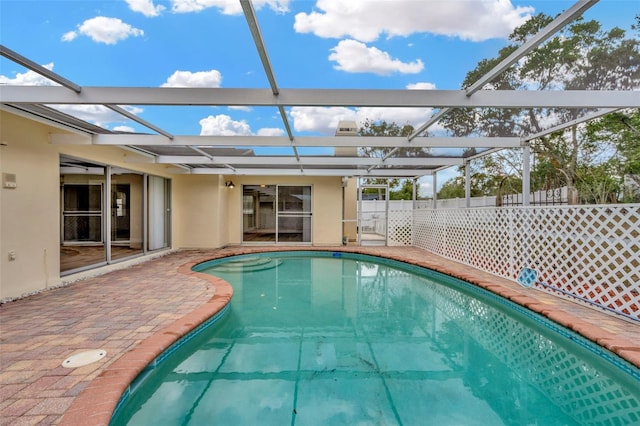 view of swimming pool with a patio area and a lanai