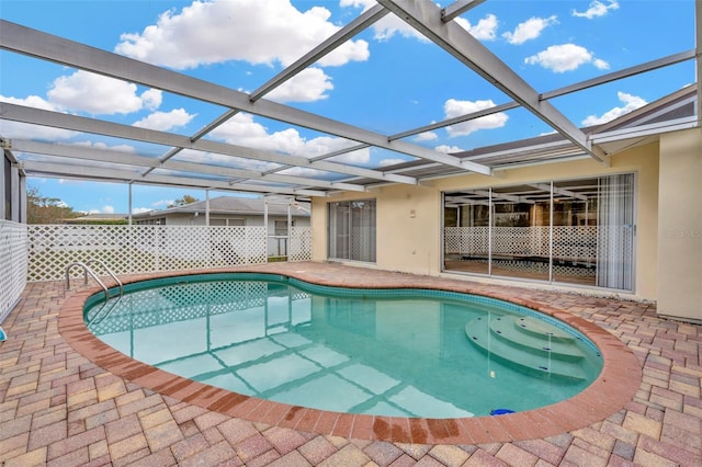 view of pool featuring glass enclosure and a patio area