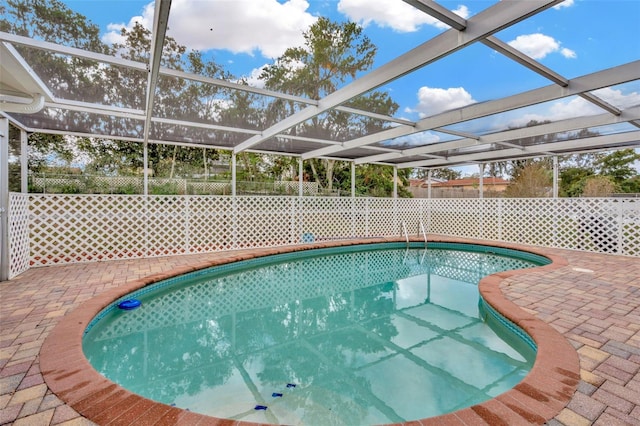 view of pool featuring glass enclosure and a patio