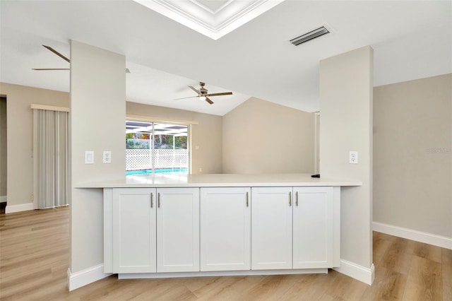 kitchen with white cabinetry, kitchen peninsula, ceiling fan, and light hardwood / wood-style flooring