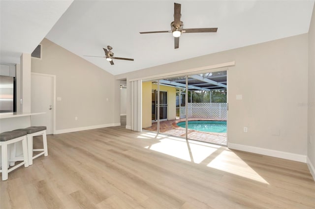 unfurnished living room featuring lofted ceiling, ceiling fan, and light hardwood / wood-style flooring