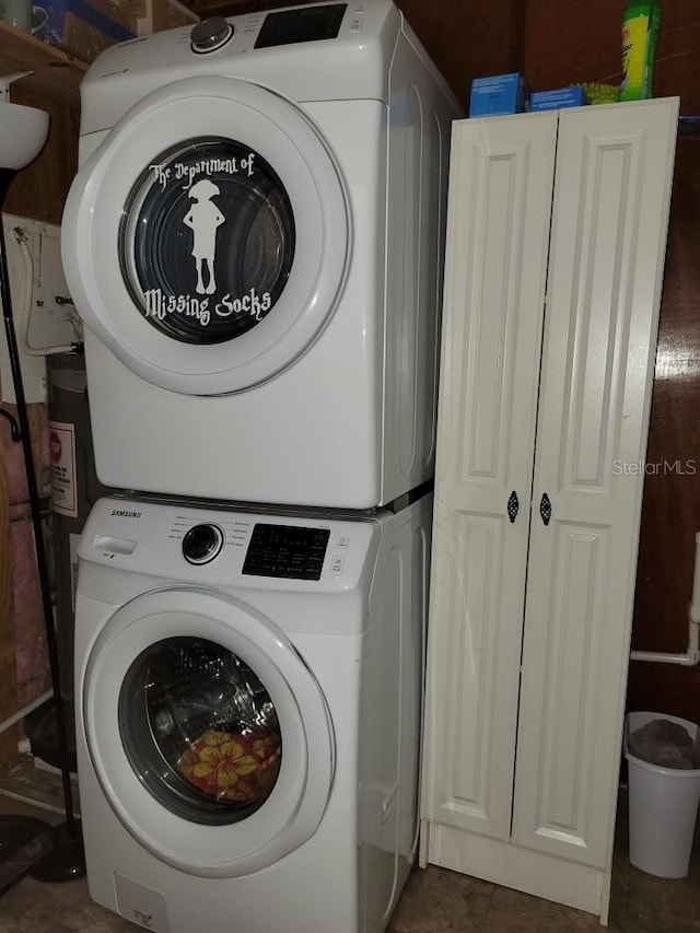 washroom featuring cabinets and stacked washer and dryer