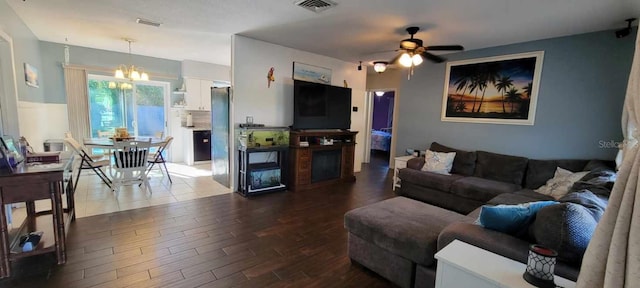 living room with ceiling fan with notable chandelier