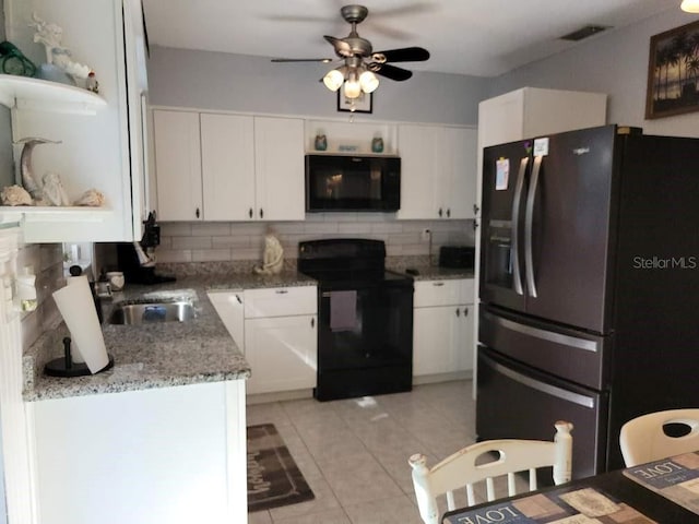 kitchen featuring tasteful backsplash, stone counters, white cabinets, and black appliances