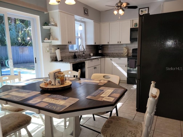 kitchen with decorative backsplash, ceiling fan, black appliances, light tile patterned floors, and white cabinetry