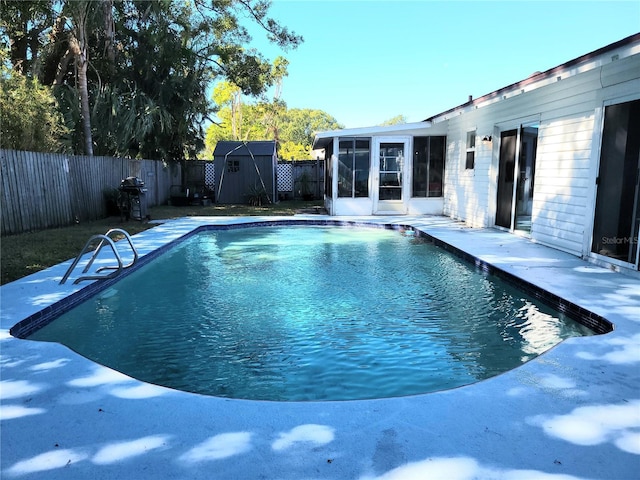 view of swimming pool with a sunroom and a shed