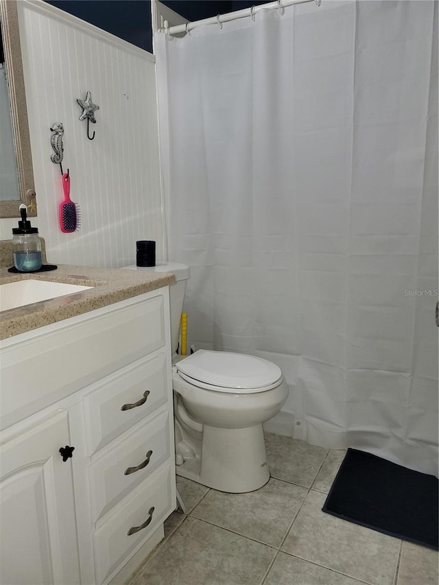 bathroom with tile patterned flooring, vanity, and toilet