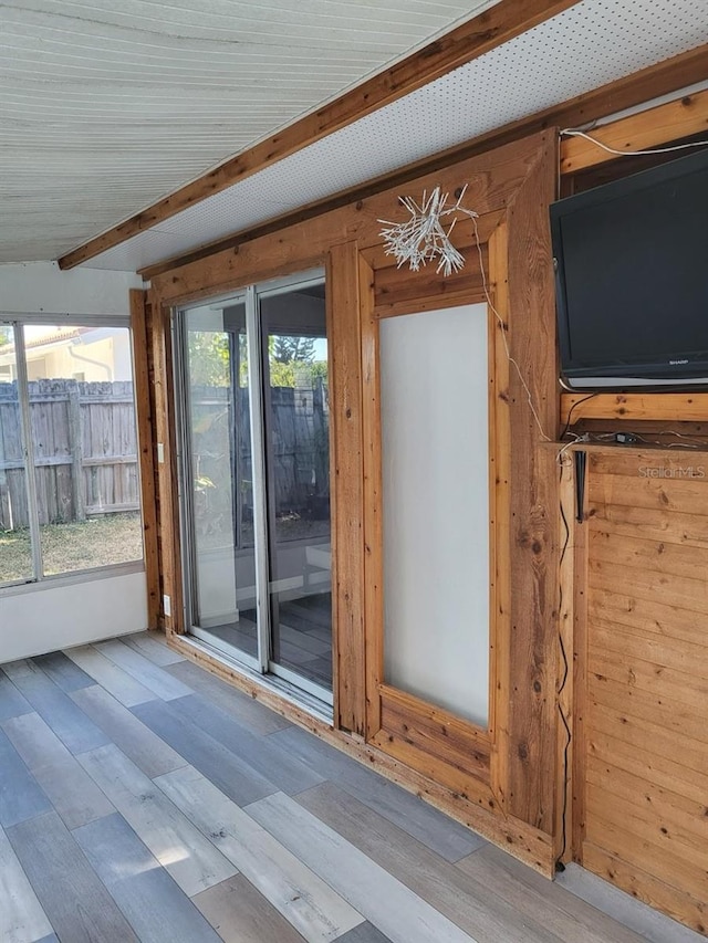 doorway featuring beamed ceiling and light hardwood / wood-style floors