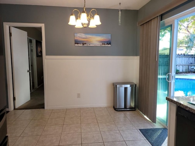 unfurnished dining area featuring light tile patterned floors and a notable chandelier